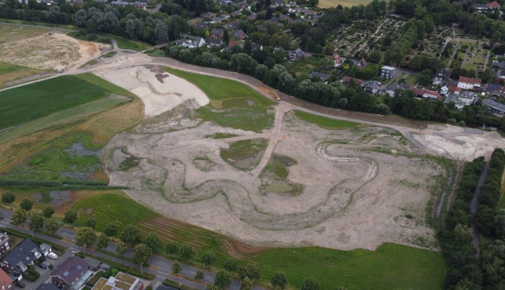 Baufeld Süd mit den vorne links neu entstandenen Feuchtwiesen auf reaktivieren Niedermohrböden